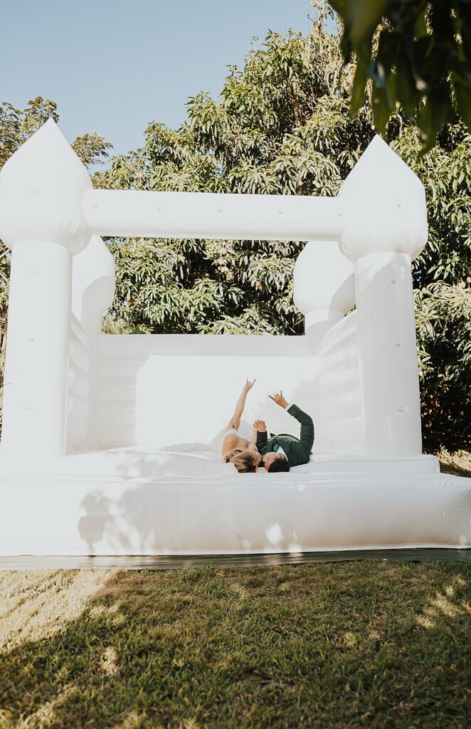 Bride and groom in white bouncy house 