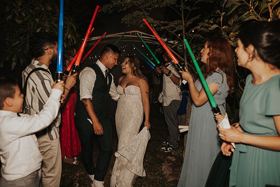 bride and groom grand exit with lightsabers 