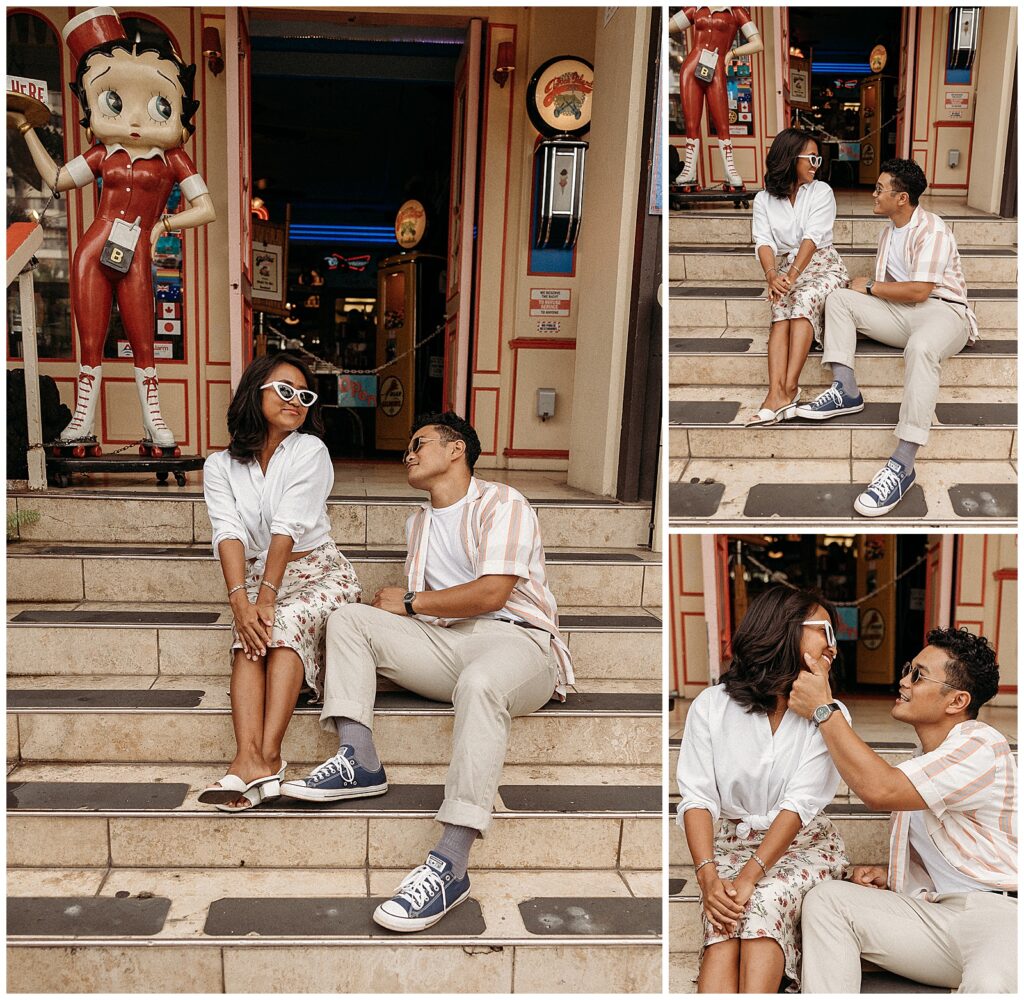 man and woman sitting on stair case in the city smiling at each other 